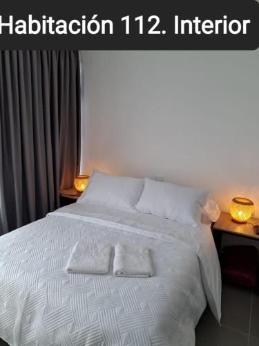 a bedroom with a white bed with two towels on it at Guatapé Country House Hotel in Guatapé