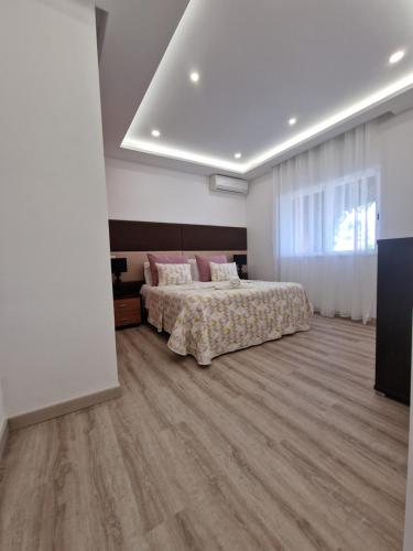 a bedroom with a bed and a wooden floor at Quinta do Baía in Lagos