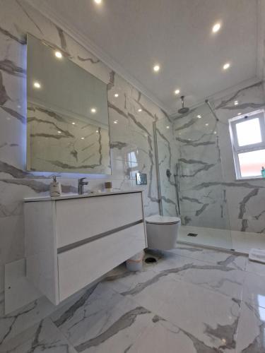 a bathroom with a white sink and a mirror at Quinta do Baía in Lagos
