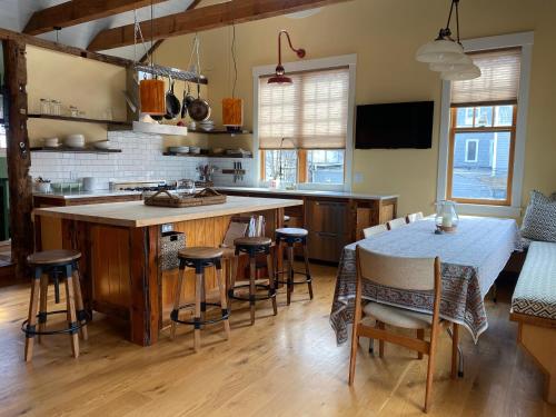 cocina con mesa, sillas y barra en Magical Post And Beam Loft Downtown Newport! en Newport