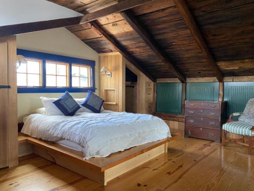 a bedroom with a large bed with blue walls and wooden ceilings at Magical Post And Beam Loft Downtown Newport! in Newport