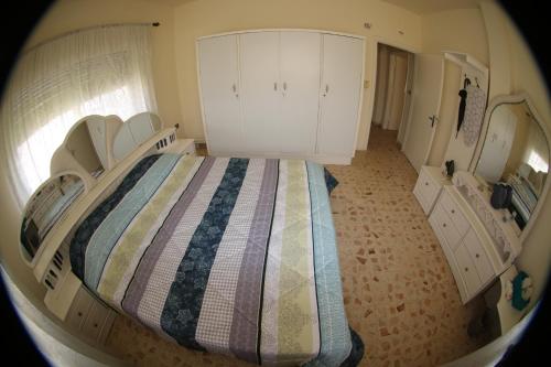 a bedroom with a bed with white cabinets at Alice & Andrew Apt. Few Steps to Madaba Old City Center in Madaba