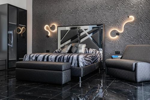a bedroom with a bed and a chair at Prezioso suites & rooms in Lecce