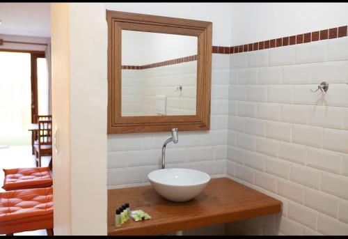 a bathroom with a white sink and a mirror at Flat Vila Taipu in Marau