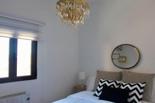 a chandelier hangs above a bed in a bedroom at El Adarve de la Inolda in Toledo
