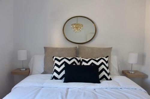 a bed with a black and white pillow and a mirror at El Adarve de la Inolda in Toledo