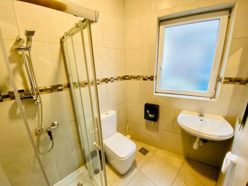 a bathroom with a toilet and a sink and a window at Marco Polo Party Hostel in St Julian's