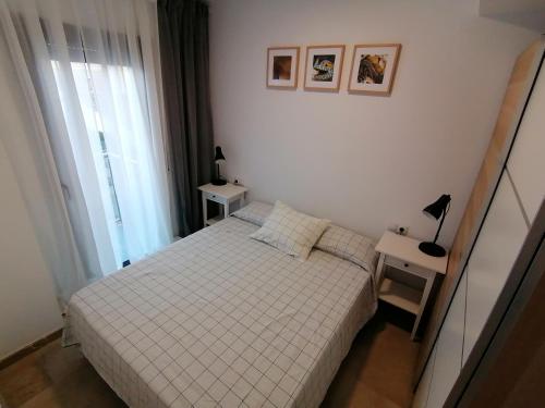 a small bedroom with a bed and a window at Piso pl 2A, 20 min Plaza Cataluña in Sant Adria de Besos