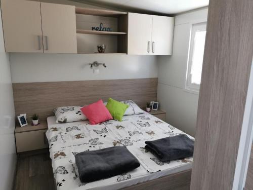 a bedroom with a bed with two pillows on it at Mediterranean mobile homes - Lotty in Drage