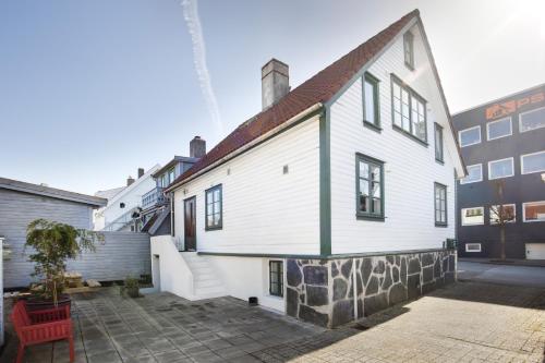 a white house with a red chair in a courtyard at Central Studio Apartment in Stavanger in Stavanger