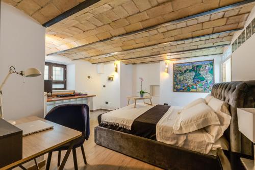a bedroom with a bed and a desk and a table with a laptop at Oliviero - Piazza Navona Apartment in Rome