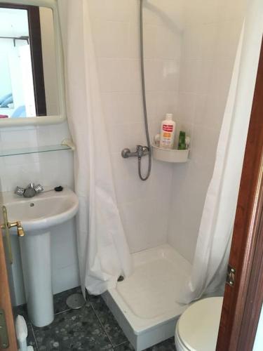 een badkamer met een douche, een toilet en een wastafel bij Tranquil apartment in Chiclana La Barrosa in Chiclana de la Frontera