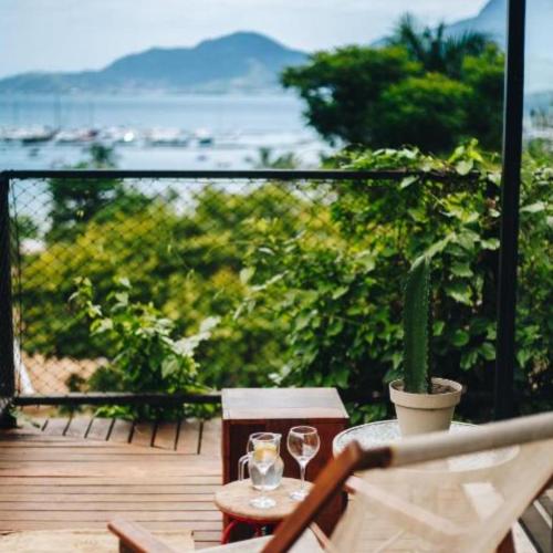 a balcony with two wine glasses and a cactus at Vila Bambu Ilhabela, Santa Tereza in Ilhabela