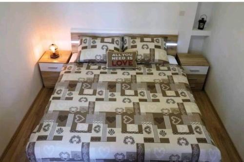 Un dormitorio con una cama con colcha que dice saber que hay amor en Apartment near Colloseum en Pula