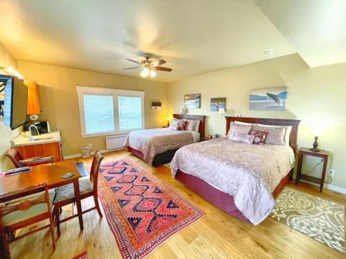 um quarto com 2 camas, uma mesa e uma secretária em Friday Harbor Grand em Friday Harbor