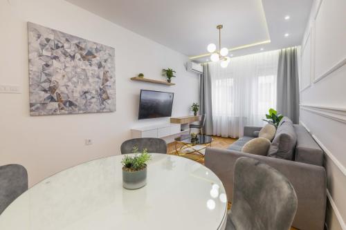 a living room with a white table and chairs at Apartment Marina in Novi Sad
