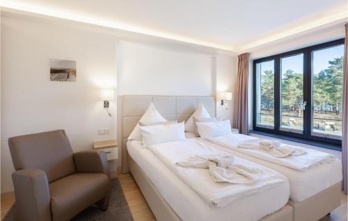 a bedroom with two beds and a chair and a window at Cloud in Binz