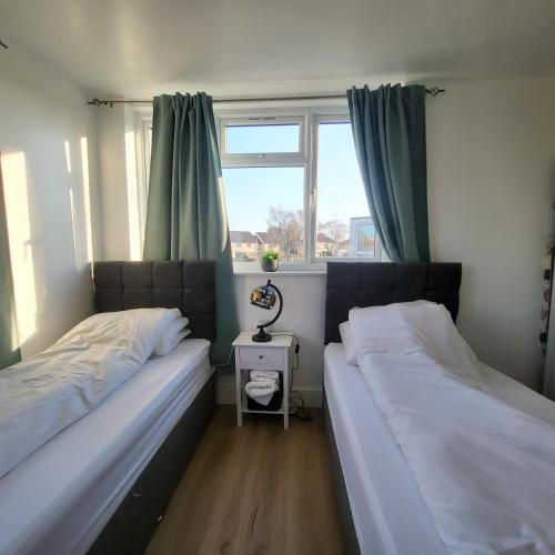 dwa łóżka w pokoju z oknem w obiekcie Fully Furnished 2 bedroom apartment with 4 single beds w Bristolu