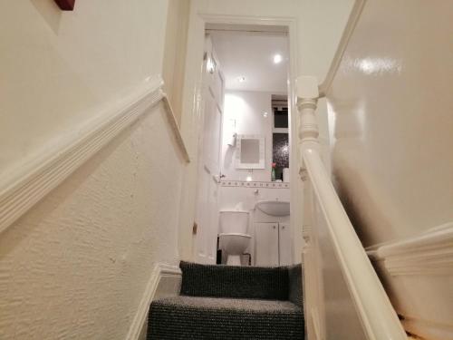 a hallway with stairs and a toilet in a room at Spacious Room near Manchester City Centre in Manchester