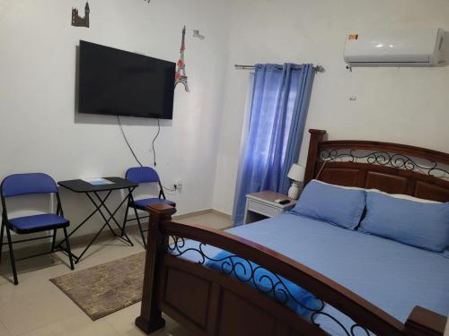 a bedroom with a bed and a flat screen tv at Sky Blue Residence in Lower Princeʼs Quarter
