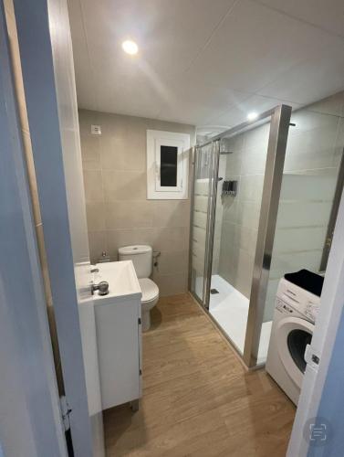 a bathroom with a toilet and a sink and a washing machine at Beta's Beach in Blanes