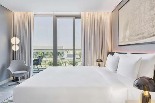 a bedroom with a large white bed and a large window at Radisson Blu Hotel Riyadh Convention and Exhibition Center in Riyadh