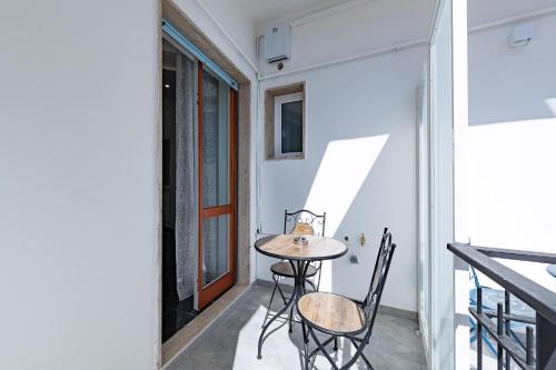 una mesa pequeña y sillas en el balcón de una casa en Prezioso suites & rooms, en Lecce
