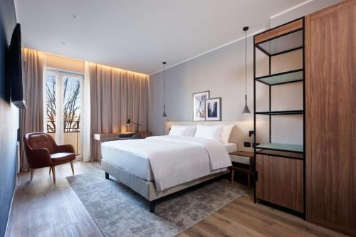 1 dormitorio con cama, escritorio y silla en Radisson Hotel Ferrara, en Ferrara
