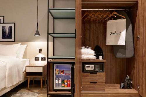 a room with a bed and a refrigerator at Radisson Hotel Ferrara in Ferrara