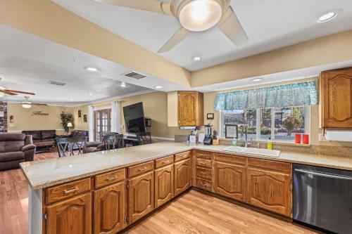 a kitchen with wooden cabinets and a living room at Spacious Desert Getaway! 1-Story, 5BR, 3 Master Suites, Casita, Pool, EV, Game Room in Las Vegas