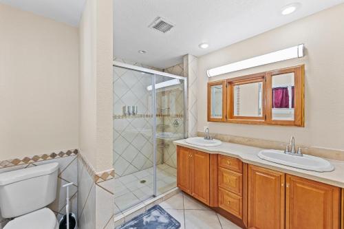 a bathroom with two sinks and a shower at Spacious Desert Getaway! 1-Story, 5BR, 3 Master Suites, Casita, Pool, EV, Game Room in Las Vegas
