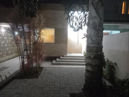 un edificio con un passaggio in mattoni con una palma di Casa Térrea-Bertioga-Uso exclusivo para de 1 a 12 pessoas a Bertioga