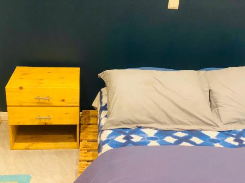 ein Schlafzimmer mit einem Bett und einem Nachttisch mit einem Bett von 6 x 6 cm in der Unterkunft Emefa Room in Cotonou