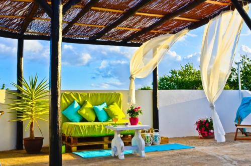 a patio with a green couch and a table at Quinta das Amendoeiras in Albufeira