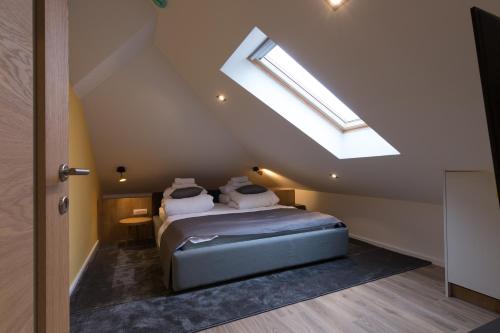 a attic bedroom with a bed with a skylight at Mayisa Apartments in Sarajevo