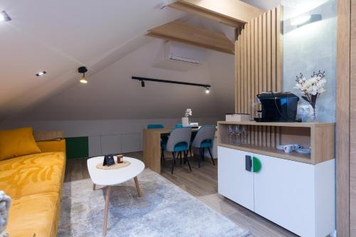 a living room with a yellow couch and a kitchen at Mayisa Apartments in Sarajevo