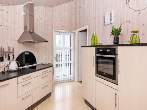 uma cozinha com armários brancos e bancadas pretas em 6 person holiday home in Hemmet em Hemmet