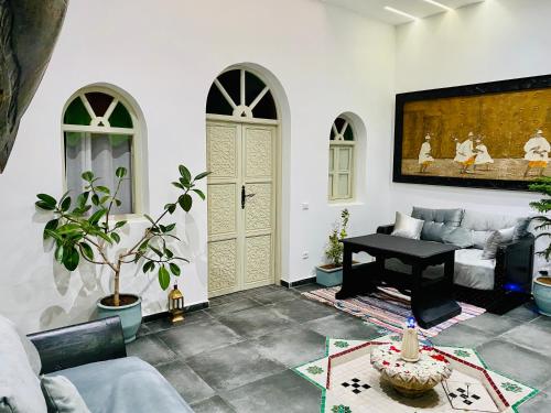 uma sala de estar com uma mesa e um piano em DAR Riad Jomana em Marraquexe