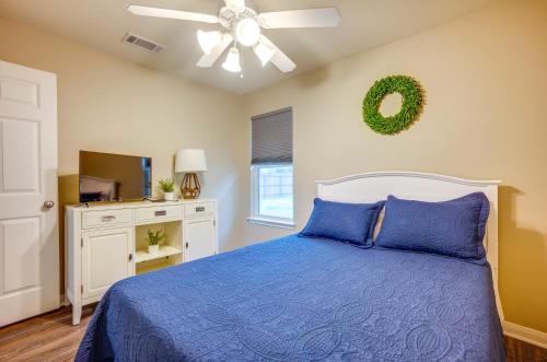 a bedroom with a blue bed and a ceiling fan at Pet-Friendly Texas Retreat with Fenced-In Yard! in Bryan