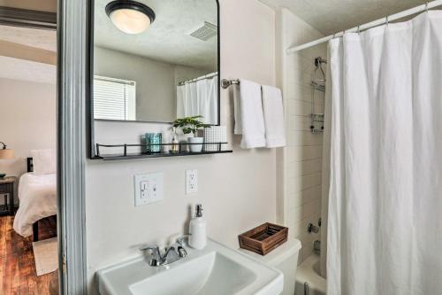 a white bathroom with a sink and a mirror at Cozy Omaha Vacation Rental 6 Miles to Downtown! in Omaha