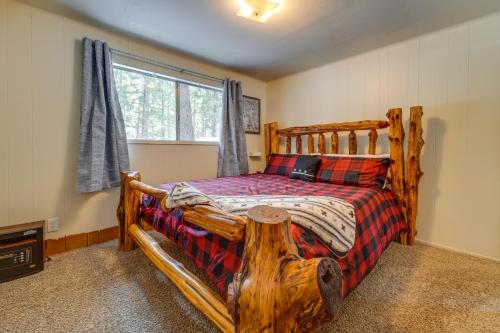 Graeagle的住宿－Graeagle Vacation Rental Cabin with Game Room!，窗户客房内的一张木床