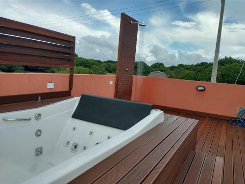 a bath tub sitting on top of a wooden deck at Flat com Terraço Pipa Beleza Resort in Pipa