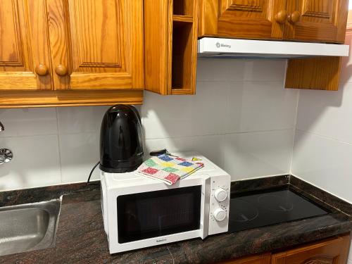 a microwave sitting on a counter in a kitchen at Practical and cozy apartment in southern Arona in Arona