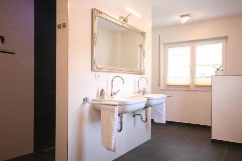 a bathroom with two sinks and a mirror at Ferienhaus Luca in Füssen