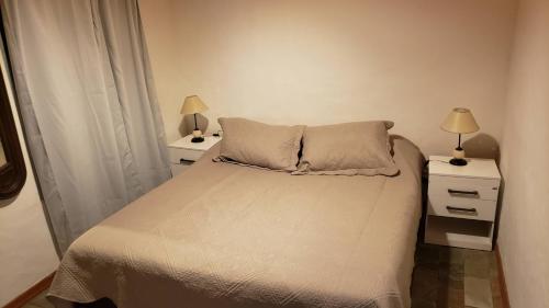 聖塔安娜的住宿－LA INESITA，一间卧室配有一张带2个床头柜和2盏灯的床。