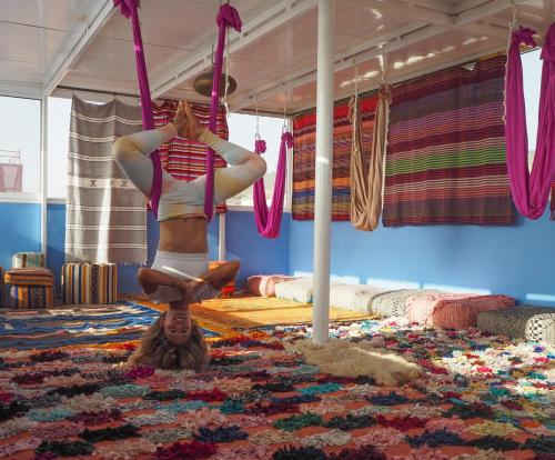 a woman is doing a flip on a swing at Surf capitain in Tamraght Ouzdar