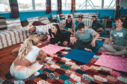 un grupo de personas sentadas en el suelo en una habitación en Surf capitain, en Tamraght Ouzdar