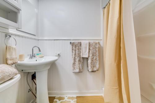 a white bathroom with a sink and a shower at Fire Pit and Boat Dock Peaceful Dunnellon Cabin! in Dunnellon