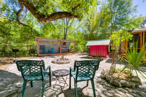 a patio with chairs and a table and a house at Fire Pit and Boat Dock Peaceful Dunnellon Cabin! in Dunnellon
