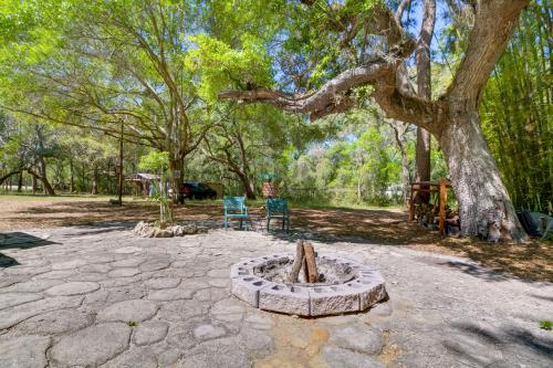 a stone patio with two chairs and a tree at Fire Pit and Boat Dock Peaceful Dunnellon Cabin! in Dunnellon